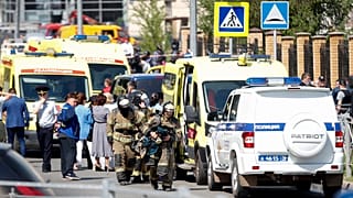 Los bomberos pasan por delante de ambulancias y coches de policía y un camión aparcado en una escuela después de un tiroteo en Kazán, Rusia, el martes 11 de mayo de 2021.
