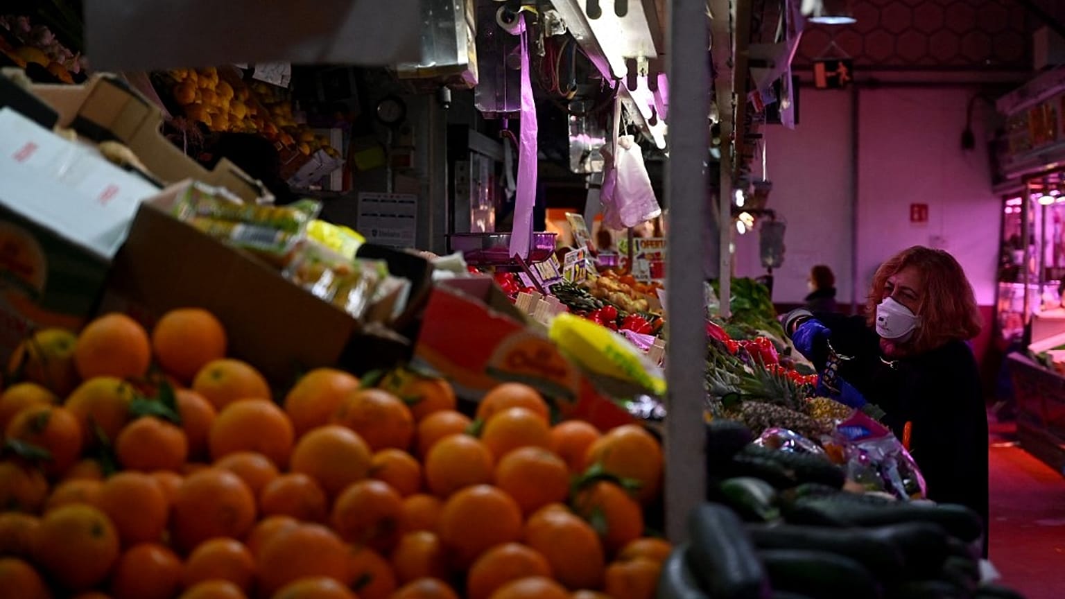 A woman checks fruit and vegetables at the Cebada market in Madrid