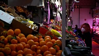 A woman checks fruit and vegetables at the Cebada market in Madrid