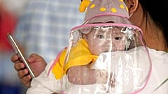 Baby mit Gesichtsschutz auf dem Flughafen in Wuhan, China, 23. Mai 2020