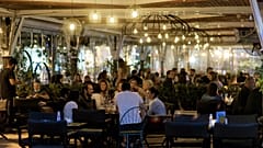 Κόσμος κάθεται σε καταστήματα εστίασης, σε εξωτερικό χώρο, στην Κόρινθο