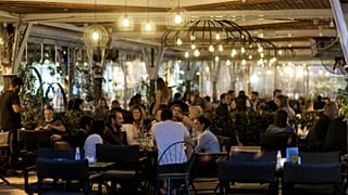 Κόσμος κάθεται σε καταστήματα εστίασης, σε εξωτερικό χώρο, στην Κόρινθο