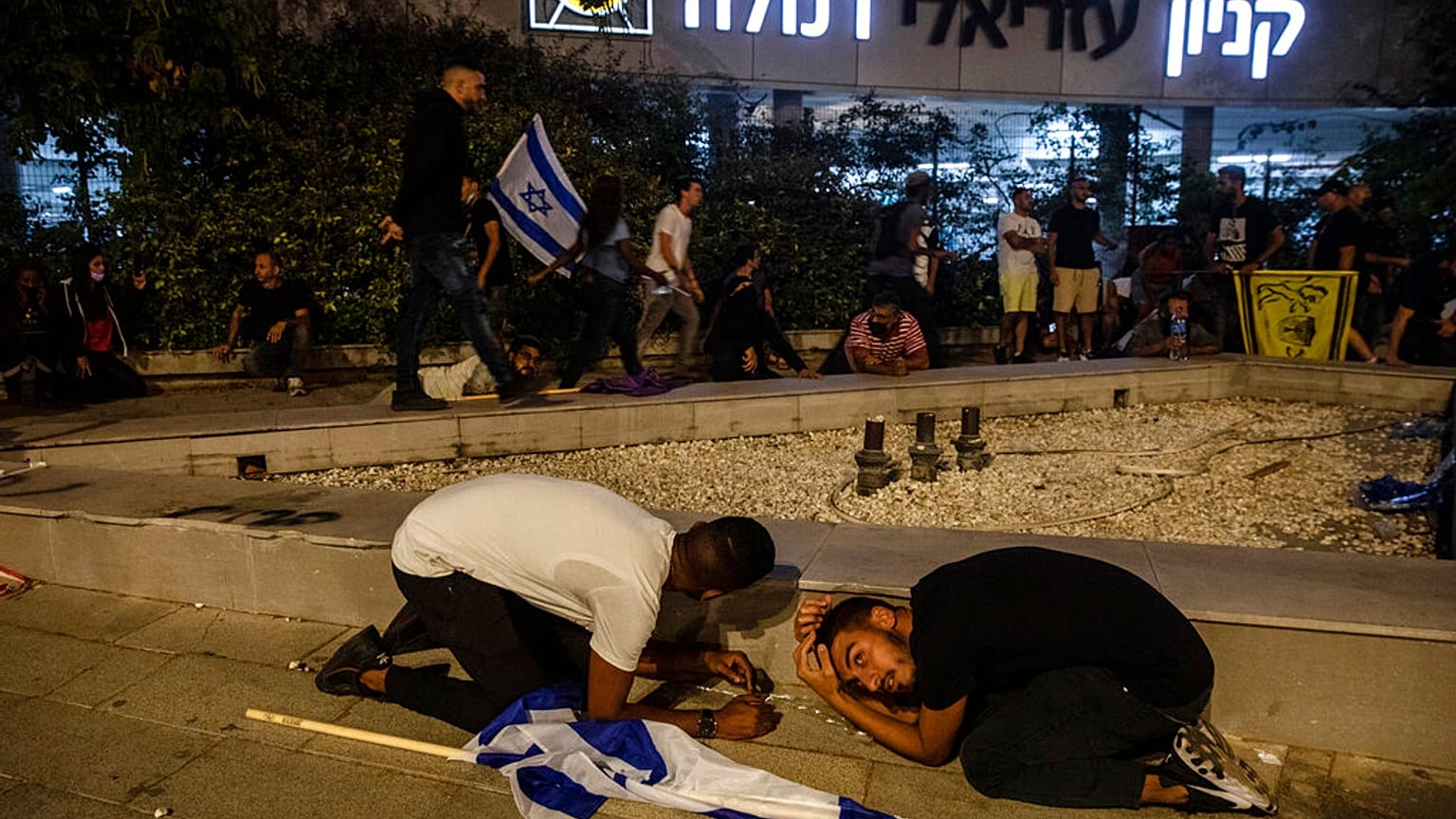 Des manifestants juifs s'abritent alors que des roquettes ont été tirées depuis Gaza, à Ramla, Israël, le 11 mai 2021