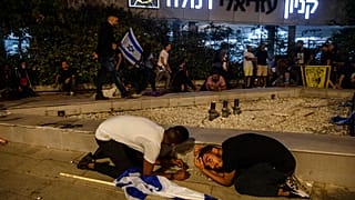 Des manifestants juifs s'abritent alors que des roquettes ont été tirées depuis Gaza, à Ramla, Israël, le 11 mai 2021