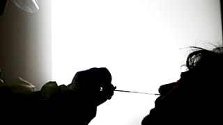 Illustrative picture: A medical staffer takes swabs as he tests for COVID-19