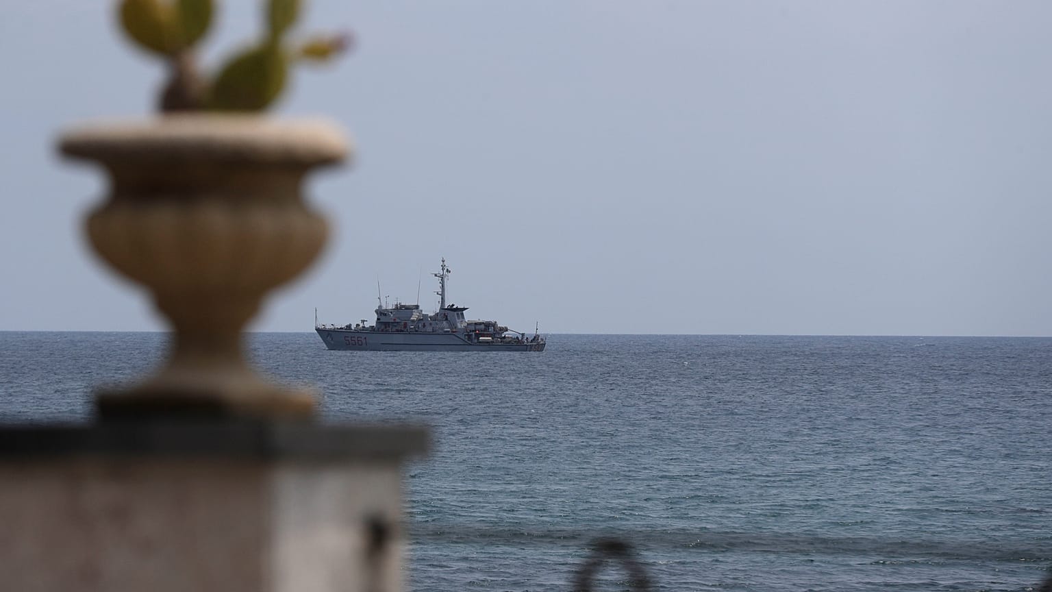 An Italian navy ship patrols the waters in front of the Sicilian town of Taormina in the Mediterranean Sea.