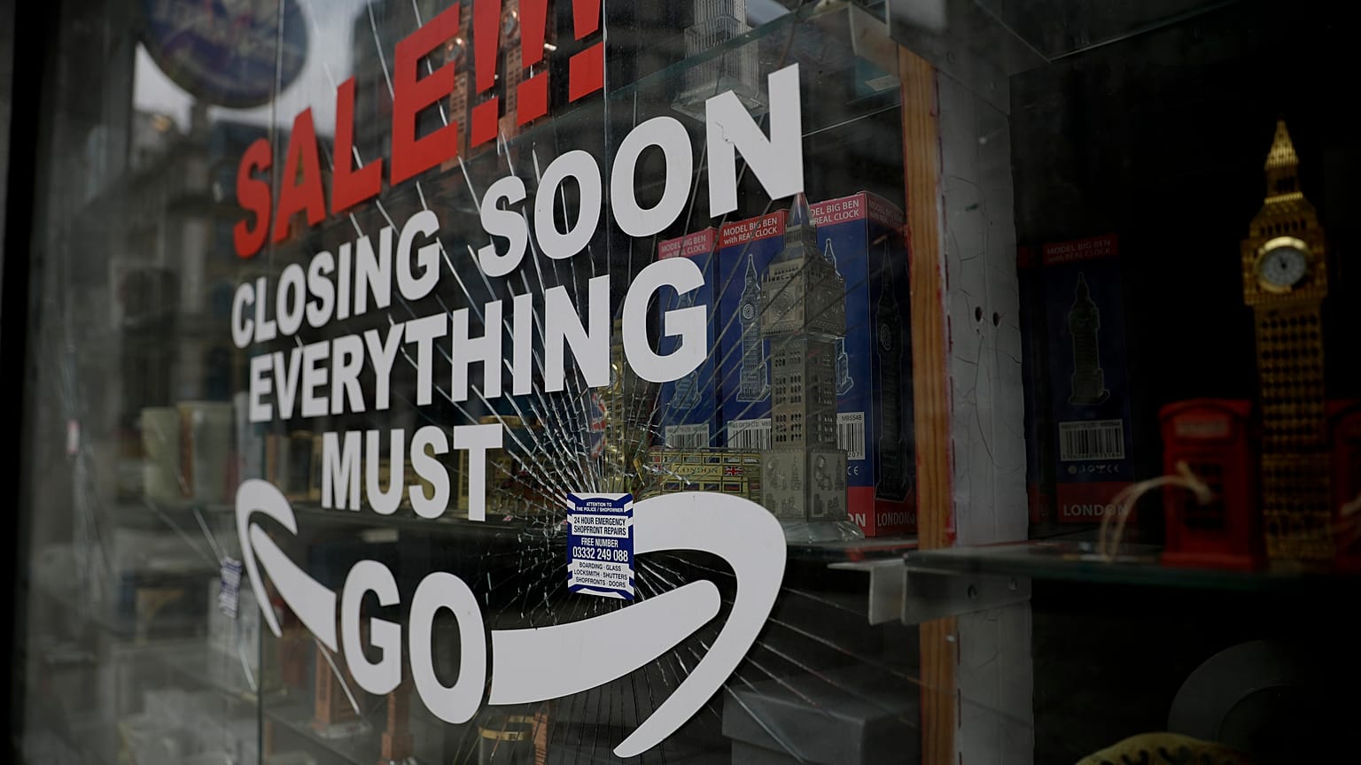 In this Friday, March 26, 2021 file photo, a shattered glass window fronts a closed souvenir store in central London, during England's third coronavirus lockdown