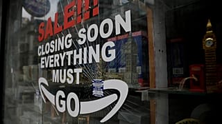 In this Friday, March 26, 2021 file photo, a shattered glass window fronts a closed souvenir store in central London, during England's third coronavirus lockdown