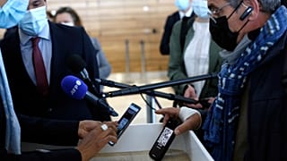 A passenger shows his mobile phone with an uploaded antigen and PCR test prior to board at the Paris-Orly airport, in Orly, south of Paris,  April 27, 2021.