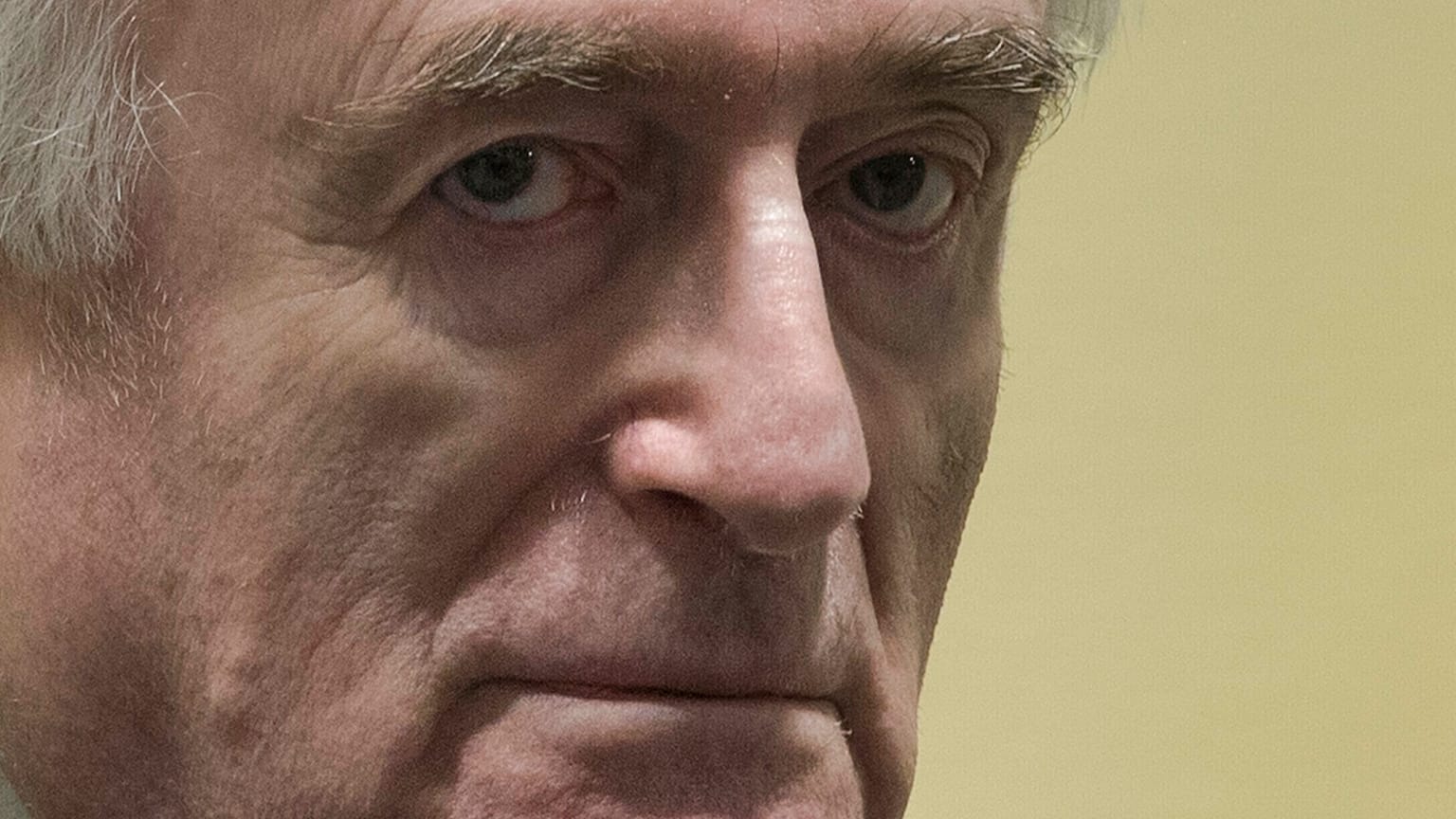 Former Bosnian Serb leader Radovan Karadzic enters the court room of the International Residual Mechanism for Criminal Tribunals in The Hague, Netherlands, Wednesday, March 20