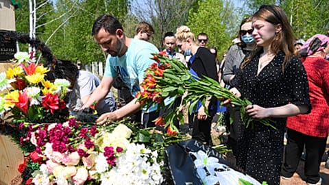 Mourners lay flowers at the grave of English teacher Elvira Ignatyeva.