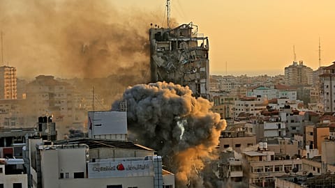 Heavy smoke and fire rise from Al-Sharouk tower as it collapses after being hit by an Israeli air strike.
