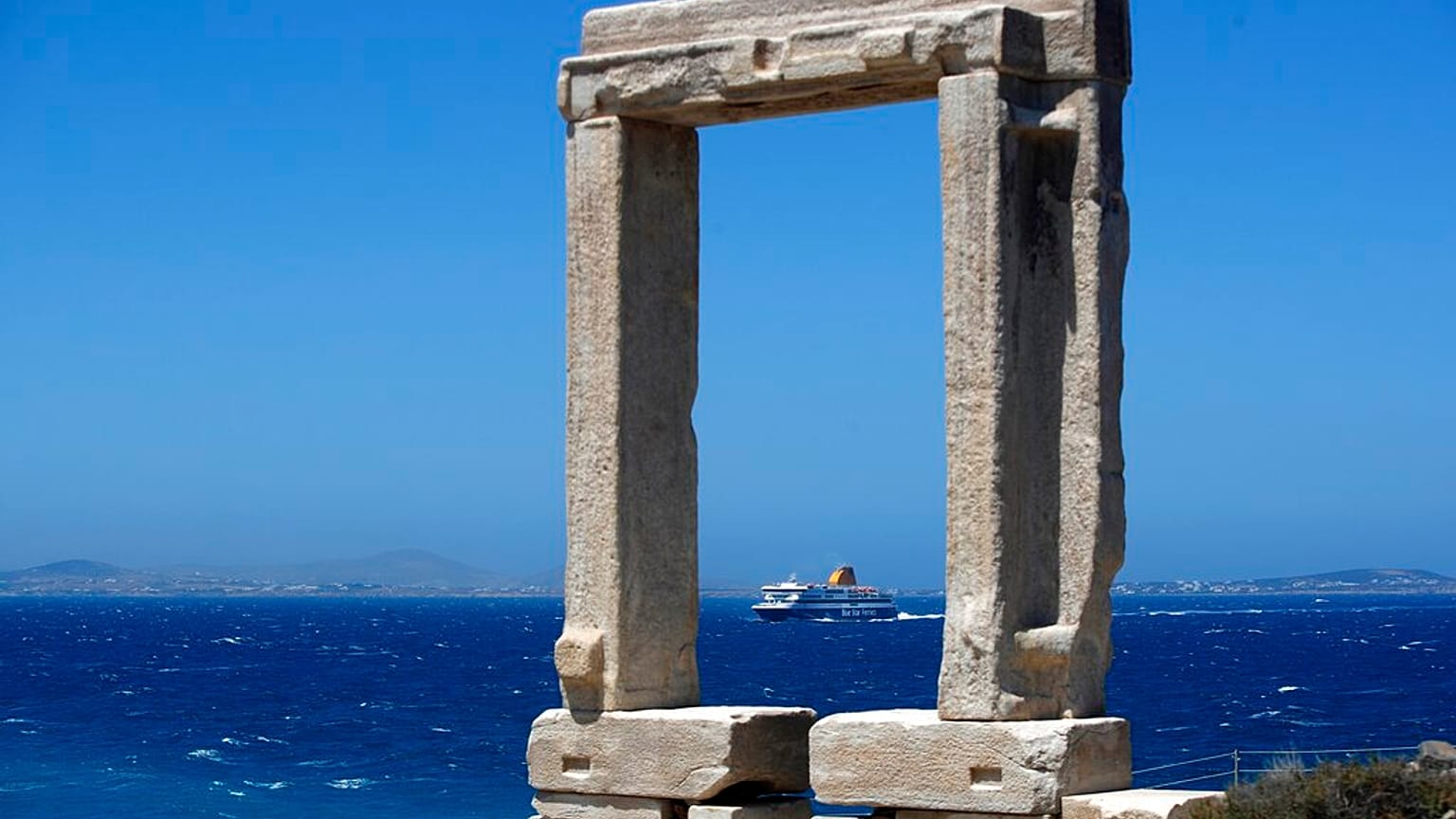Un ferry se acerca al puerto de Portara en la isla de Naxos, Grecia