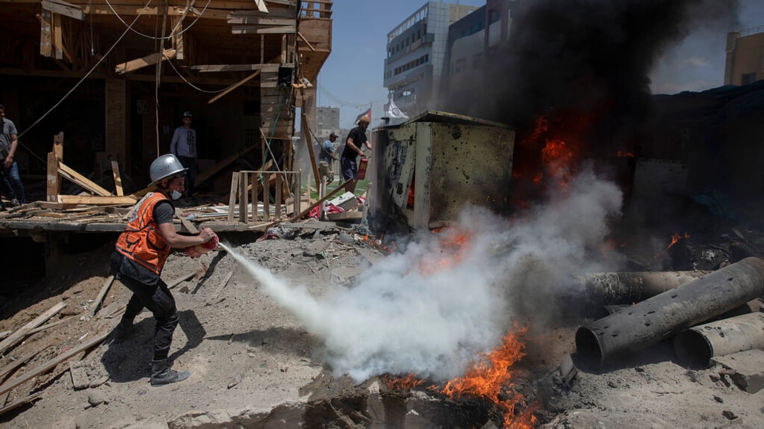 A Palestinian firefighter extinguishes a fire from a beachside cafe after it was hit by an Israeli airstrike, in Gaza City, Monday, May 17, 2021.