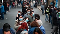 Cientos de personas aguardan en largas filas el momento de entrar en un colegio electora len Santiago de Chile.