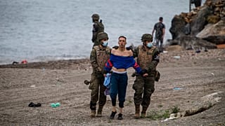 A man from Morocco is detained by soldiers of the Spanish Army at the border of Morocco and Spain, at the Spanish enclave of Ceuta, on Tuesday, May 18, 2021