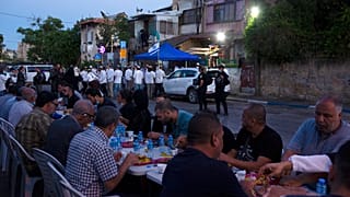 maggio 2021: a Sheikh Jarrah un gruppo di palestinesi rompe il digiuno di Ramadan sotto lo sguardo dei coloni e della polizia israeliana