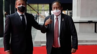 French President Emmanuel Macron, left, welcomes Sudanese Prime Minister Abdalla Hamdok at the summit to support Soudan, Monday, May 17, 2021