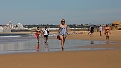 Turistas pasean por la playa en el Algarve