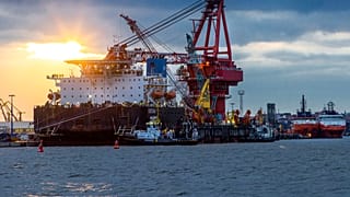 Tugboats get into position on the Russian pipe-laying vessel "Fortuna" in the port of Wismar, Germany, ahead of work on Nord Stream 2