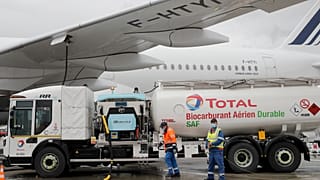 Workers refuel an Airbus A350 with sustainable aviation fuel at Roissy airport, north of Paris, Tuesday, May 18, 2021.