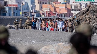 Inmigrantes menores marroquíes escoltados por las fuerzas del orden españolas en Ceuta