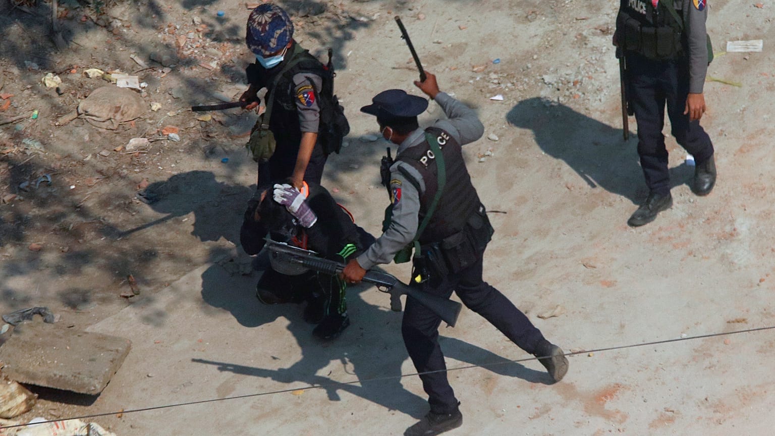 riot police officers hold down a protester as they disperse protesters 