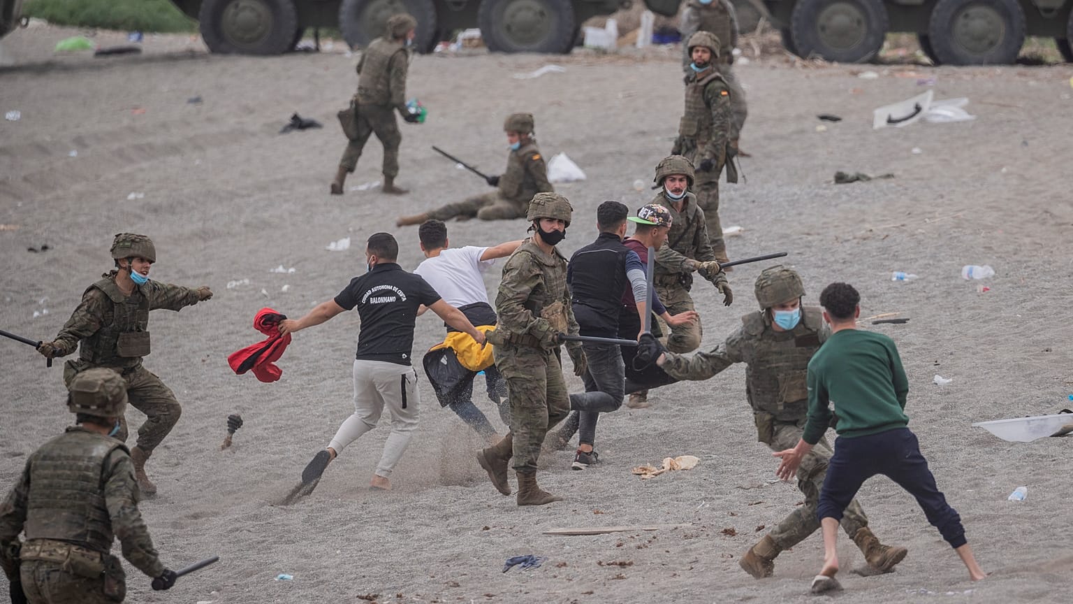 Un grupo de soldados se enfrenta a migrantes en la playa de Ceuta