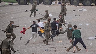 Un grupo de soldados se enfrenta a migrantes en la playa de Ceuta