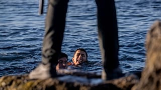 Un guardia civil español espera la llegada de migrantes al enclave español de Ceuta, cerca de la frontera de Marruecos y España, el miércoles 19 de mayo de 2021.