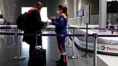 A member of Civil Protection checks air travellers documents at Paris Charles de Gaulle airport