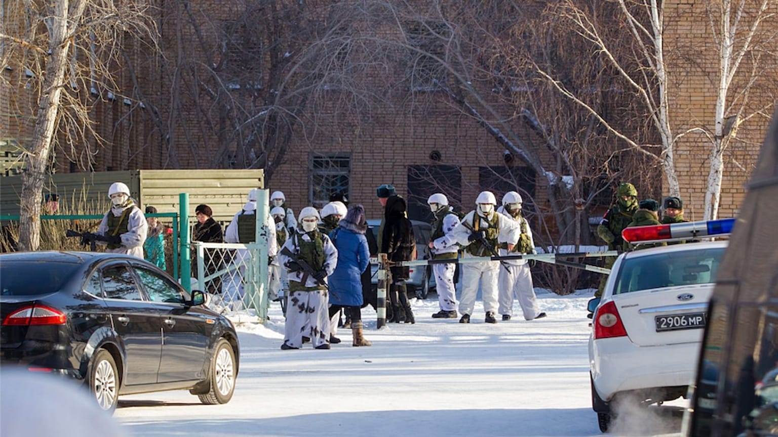 Armed police officers block an area around a school in Sosnovy Bor on the outskirts of Ulan-Ude, the regional capital of Buryatia.