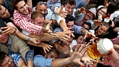Menschen greifen bei der Eröffnung des 186. Oktoberfestes in München nach einem Glas Bier (2019) 