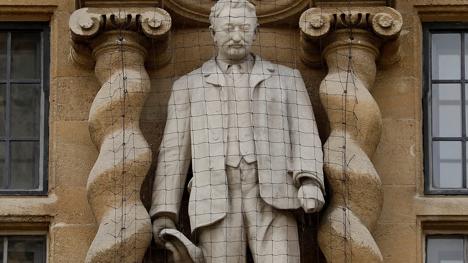 A statue of Cecil Rhodes, a controversial Victorian imperialist, stands mounted on the facade of Oriel College in Oxford, England, June 17, 2020.