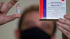A Uniao Quimica pharmaceutical employee holds a vial at the company's control center for the Russian Sputnik V COVID-19 vaccine 