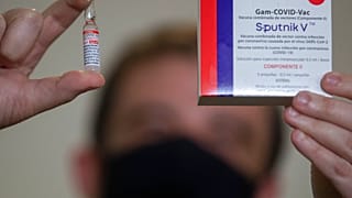A Uniao Quimica pharmaceutical employee holds a vial at the company's control center for the Russian Sputnik V COVID-19 vaccine 