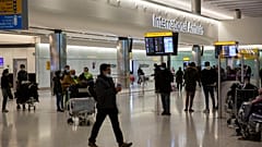People wait and arrive in the arrivals area at Heathrow Airport in London, Tuesday, Jan. 26, 2021.