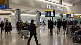 People wait and arrive in the arrivals area at Heathrow Airport in London, Tuesday, Jan. 26, 2021.