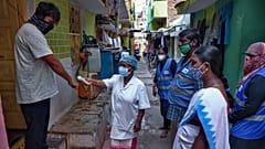 In this May 6, 2021 photo, an Indian health worker checks body temperatures during a door-to-door survey being conducted as a precaution against COVID-19 in Hyderabad, India.
