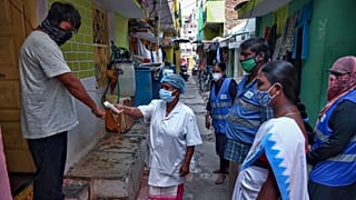 In this May 6, 2021 photo, an Indian health worker checks body temperatures during a door-to-door survey being conducted as a precaution against COVID-19 in Hyderabad, India.