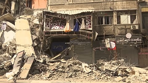 Dresses hanging from destroyed shop windows, damaged by the Israeli airstrikes
