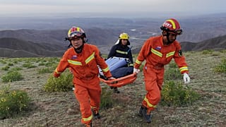 This photo taken on May 22, 2021 shows rescuers carrying equipment as they search for runners who were competing in a 100-kilometre cross-country mountain race.