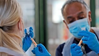 Doctor Anil Mehta and Apprentice Nursing Associate Ellie Bull prepare syringes with doses of the AstraZeneca vaccine at the Welcome Centre in Ilford, on Feb. 5, 2021 