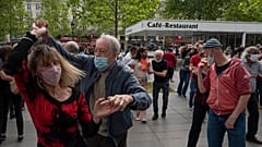 Una pareja con mascarillas baila en la plaza de la República en París, el domingo 23 de mayo de 2021.