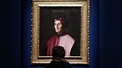 A woman looks at a portrait of poet Dante Alighieri at an exhibition, in Forlì, Italy, Saturday, May 8, 2021