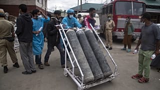 Local men hired by administration assist transport of oxygen cylinders in the premises of a hospital in Srinagar, Indian controlled Kashmir, Sunday, May 23, 2021. 