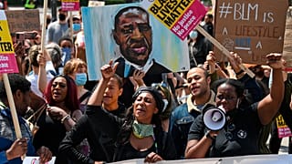 In this Saturday, June 13, 2020 file photo Sasha Johnson, center, of the Black Lives Matter movement attends a protest at Hyde Park in London.