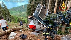 Rescuers work by the wreckage of a cable car after it collapsed near the summit of the Stresa-Mottarone line in the Piedmont region, northern Italy, Sunday, May 23, 2021.