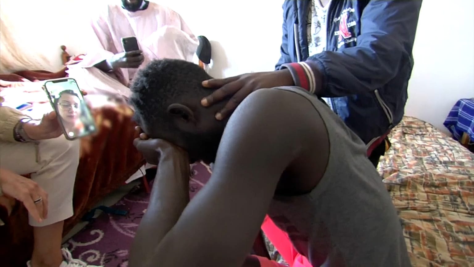 Abdou, emocionado cuando ve en el teléfono a Luna, la voluntaria que le abrazó en la playa de Ceuta