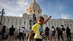Un niño sostiene su puño en alto en una concentración organizada por el primer aniversario del asesinato de George Floyd el lunes 24 de mayo de 2021